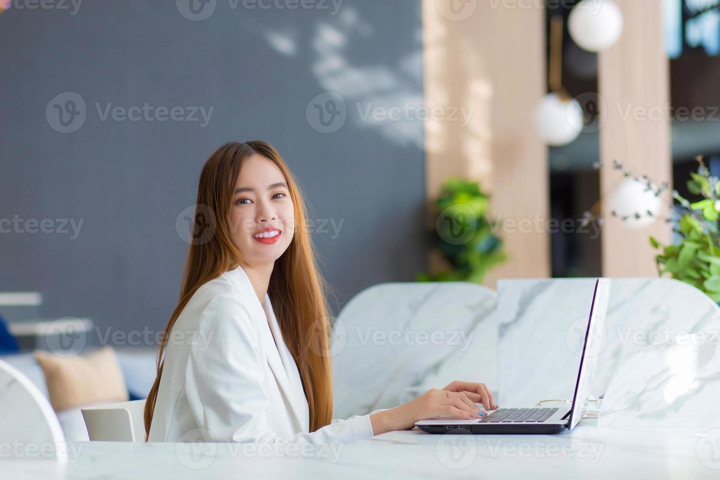 jonge Aziatische zakenvrouw werken in co-working ruimte met laptop papierwerk zakenvrouw concept. foto