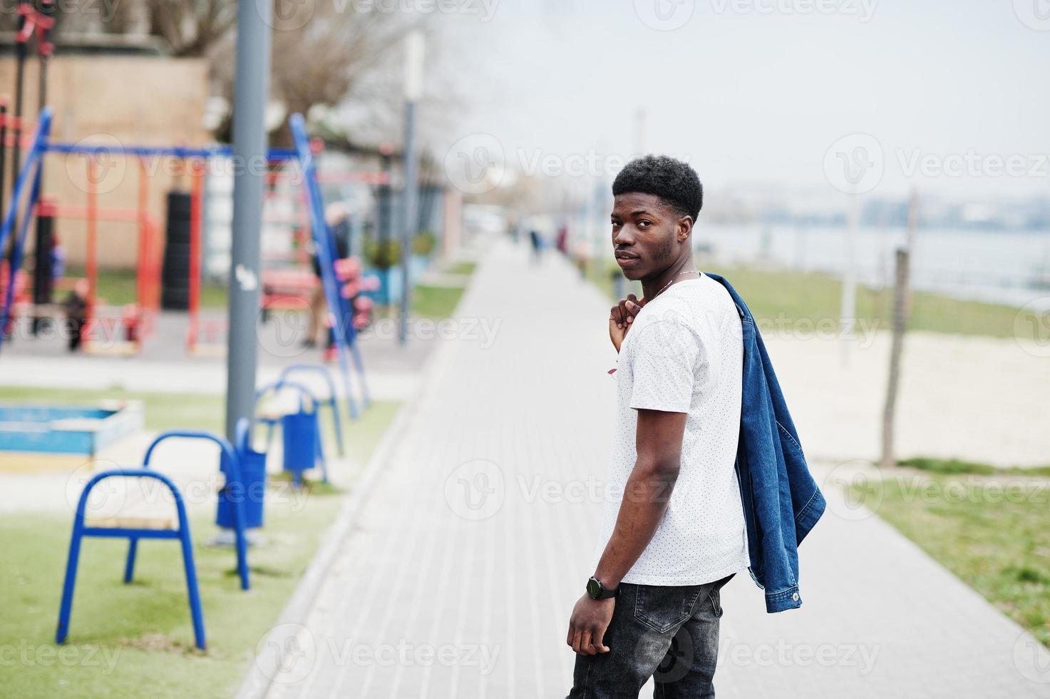 jonge duizendjarige afrikaanse jongen in de stad. gelukkig zwarte man in jeans jasje. generatie z-concept. foto