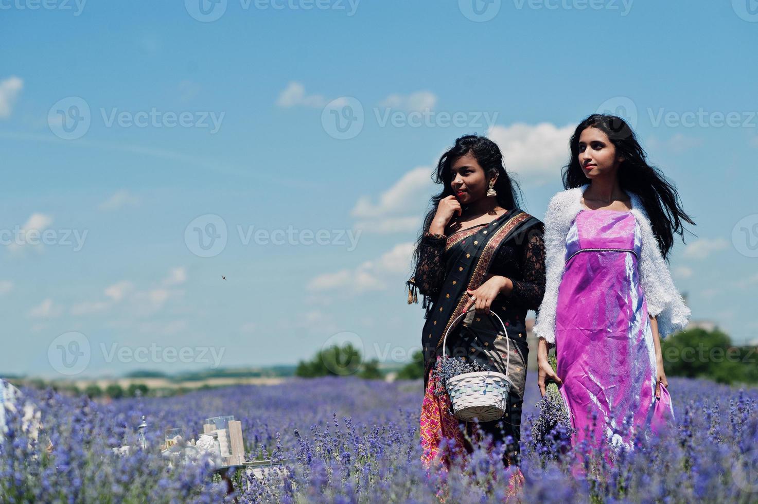 twee mooie indiase meisjes dragen saree india traditionele kleding in paars lavendelveld. foto