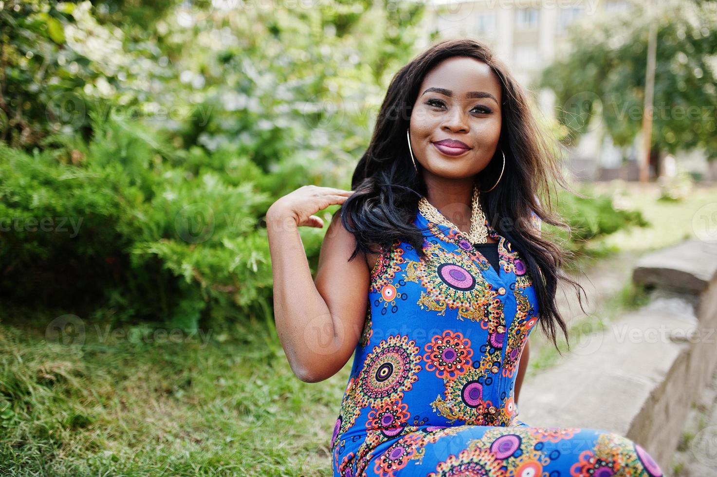 Afro-Amerikaanse meisje in gekleurde kleding buiten zitten. modieuze zwarte vrouw. foto