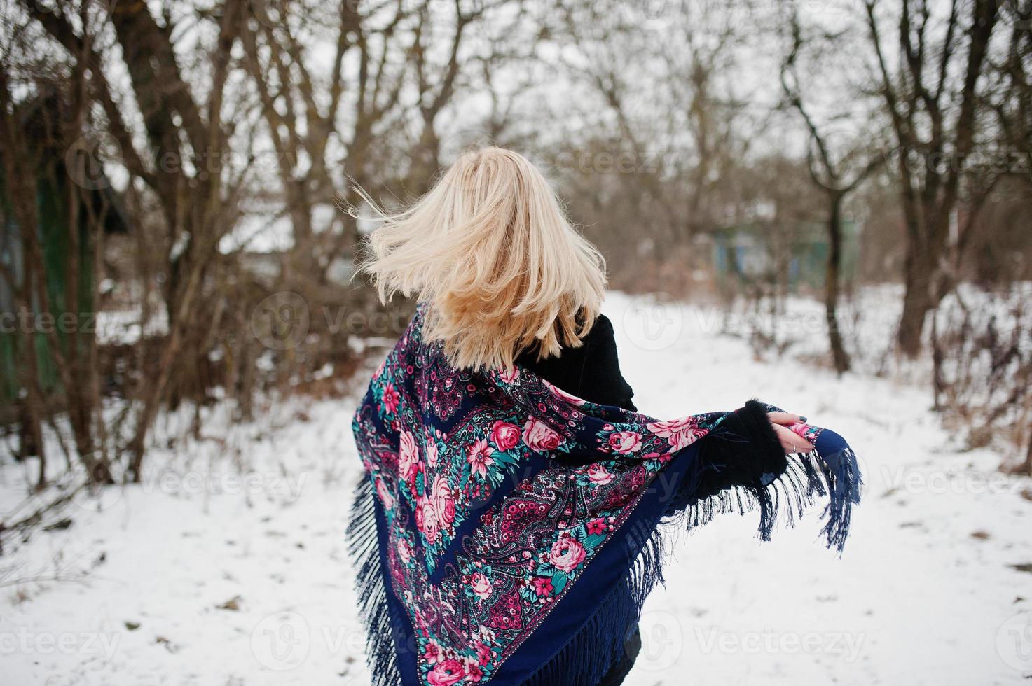 blond meisje met hand geborduurde sjaal gesteld op winterdag. dames zakdoek. foto