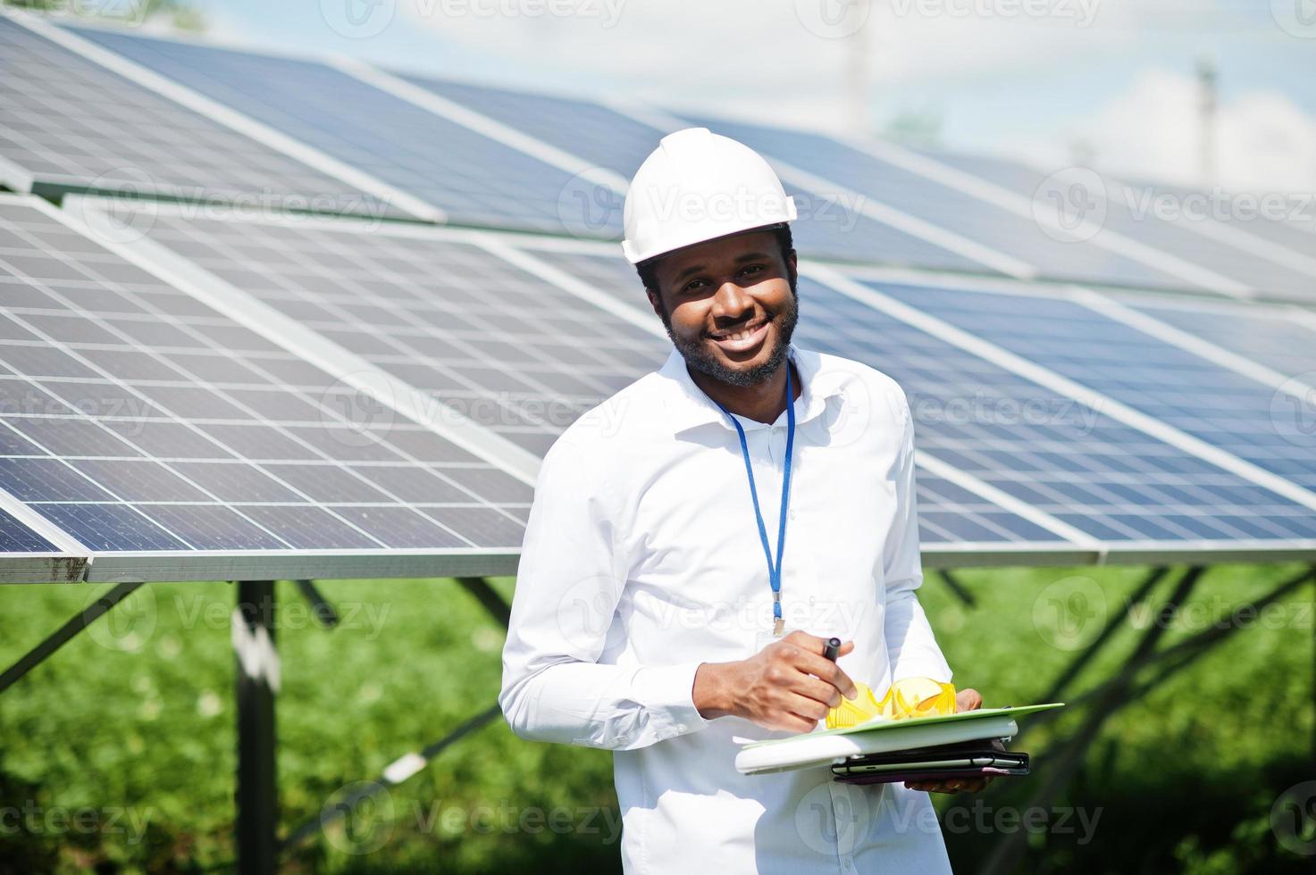 Afro-Amerikaanse technicus controleert het onderhoud van de zonnepanelen. zwarte man ingenieur bij zonnestation. foto