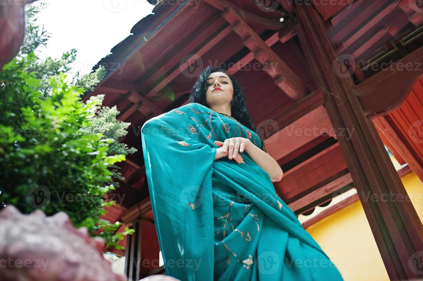 portret van mooie Indiase brumette meisje of hindoe vrouw model tegen japans traditioneel huis. foto