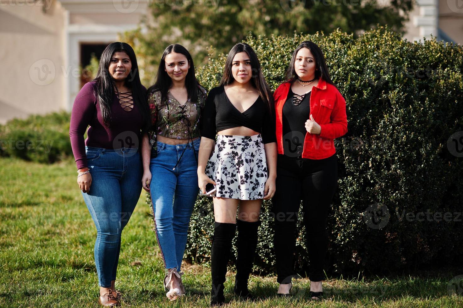 groep van vier gelukkige en mooie latino-meisjes uit ecuador poseerden op straat. foto