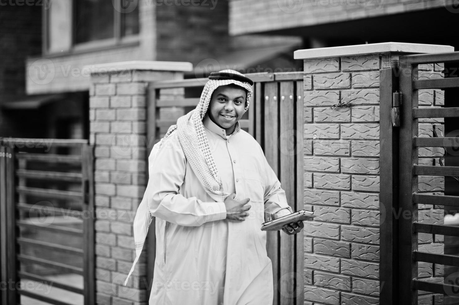 Arabische man uit het Midden-Oosten poseerde op straat tegen modern gebouw met tablet bij de hand. foto