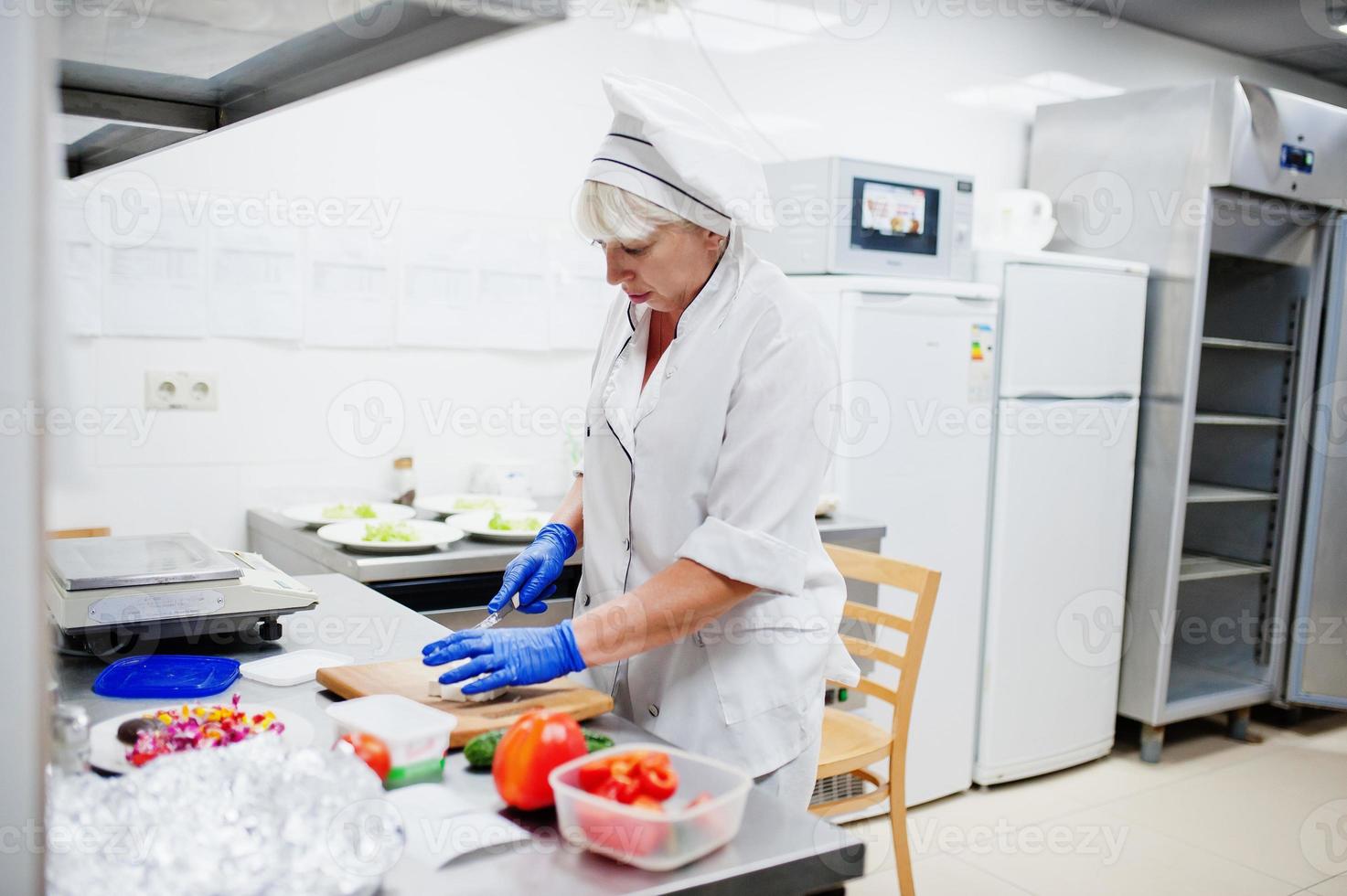 vrouwelijke chef-kok die salade in Italiaanse restaurantkeuken voorbereidt. foto