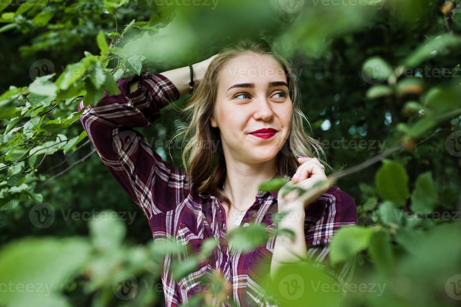 close-up portret van een lachend blond meisje in tartan shirt op het platteland. foto