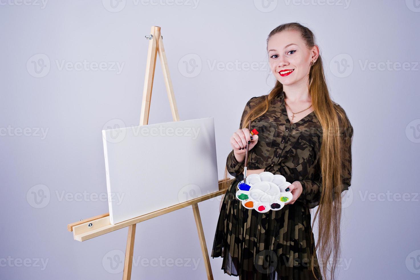 mooie vrouw kunstenaar schilder met borstels en olie canvas poseren in studio geïsoleerd op wit. foto