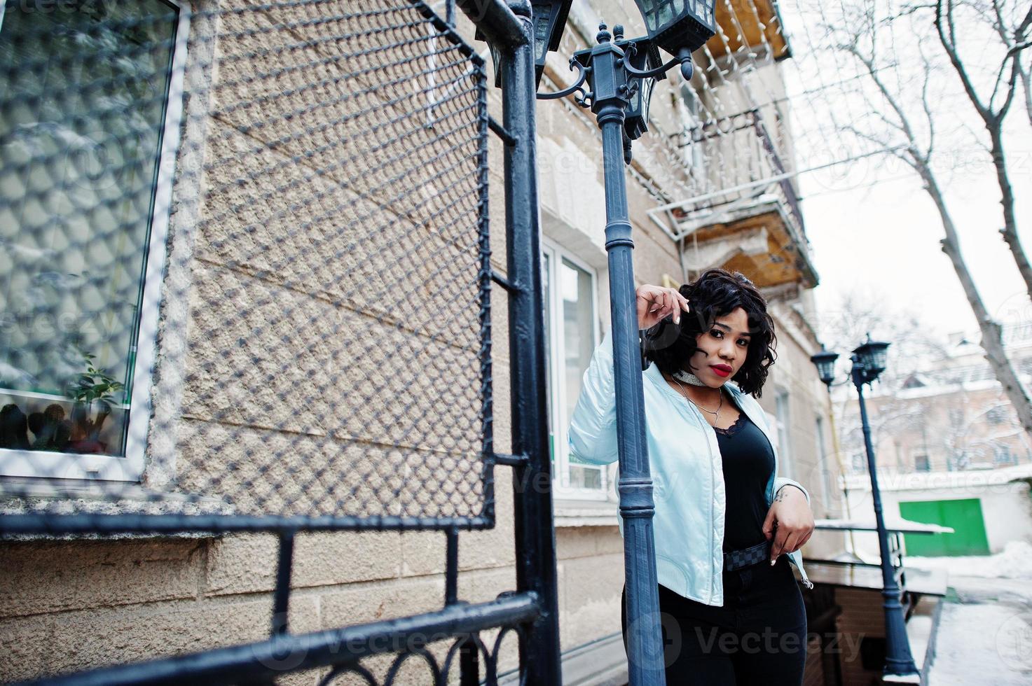 stijlvolle Afro-Amerikaanse plus size model in de straten van de stad op winterdag. foto