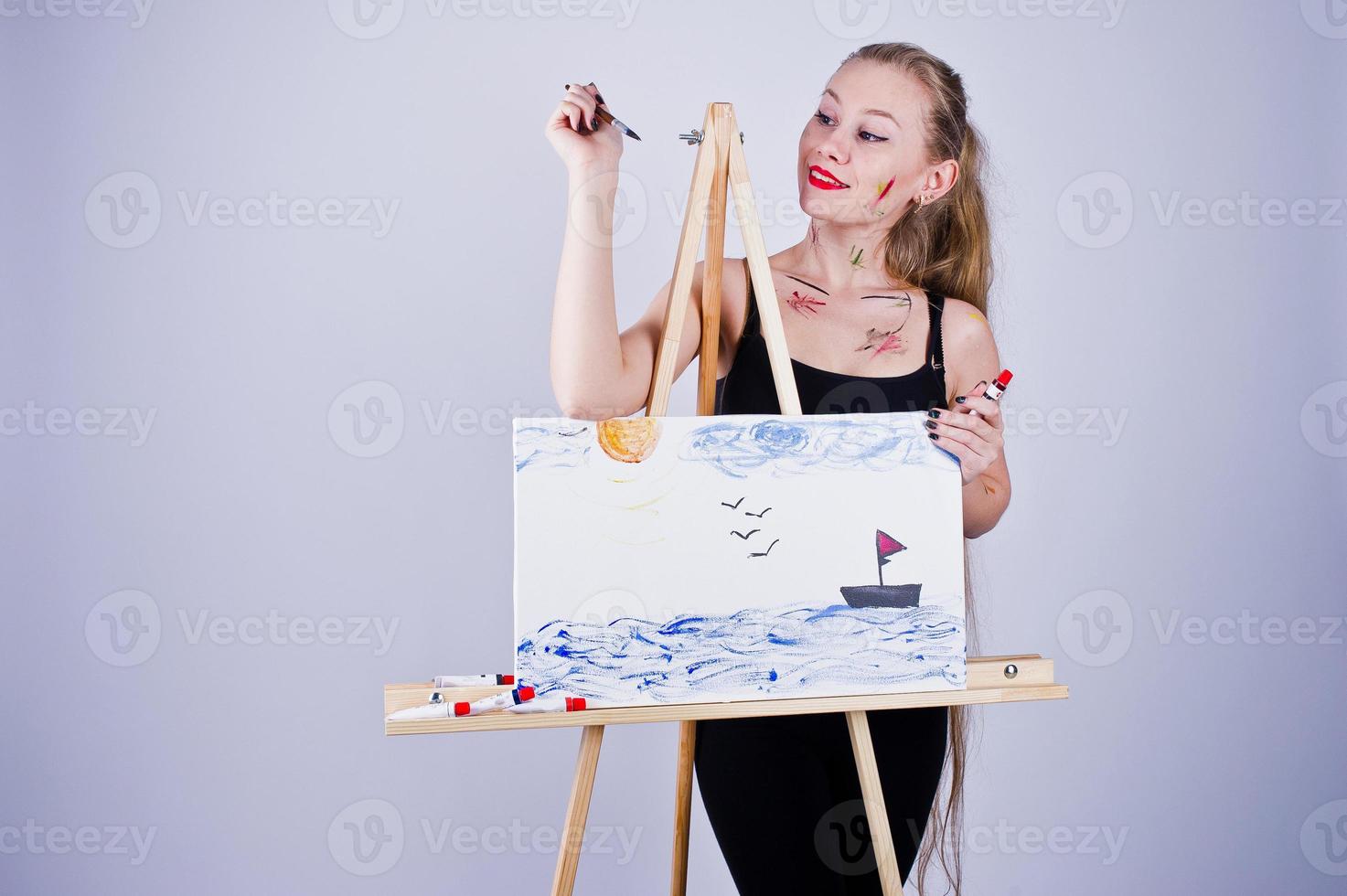 mooie vrouw kunstenaar schilder met borstels en olie canvas poseren in studio geïsoleerd op wit. foto