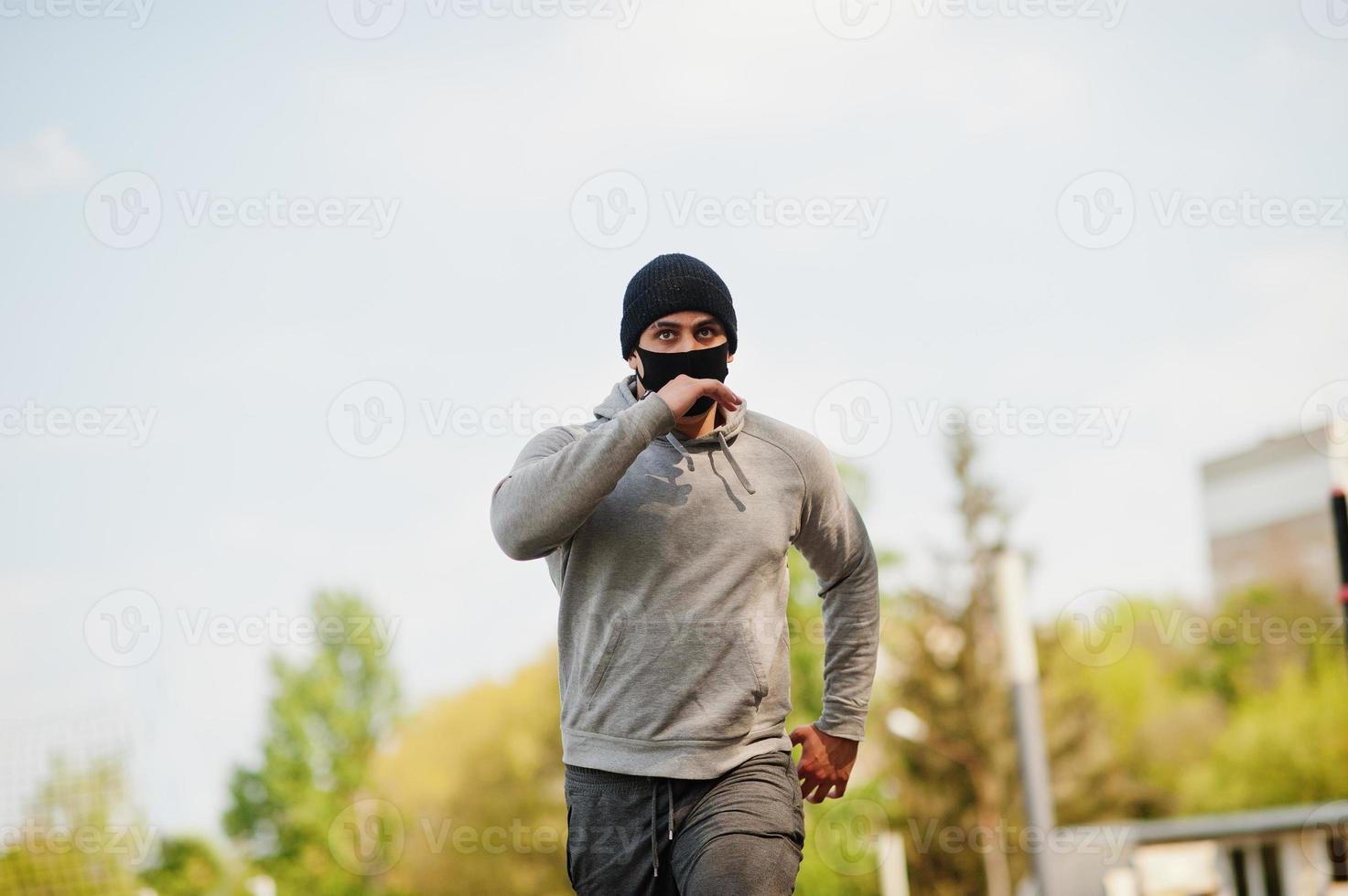 portret sport arabische man met zwart medisch gezichtsmasker buiten rennen tijdens de quarantaine van het coronavirus. foto