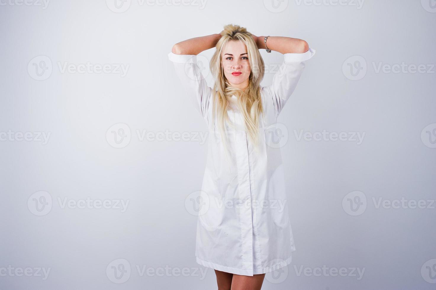 aantrekkelijke blonde vrouwelijke arts of verpleegkundige in laboratoriumjas geïsoleerd op een witte achtergrond. foto