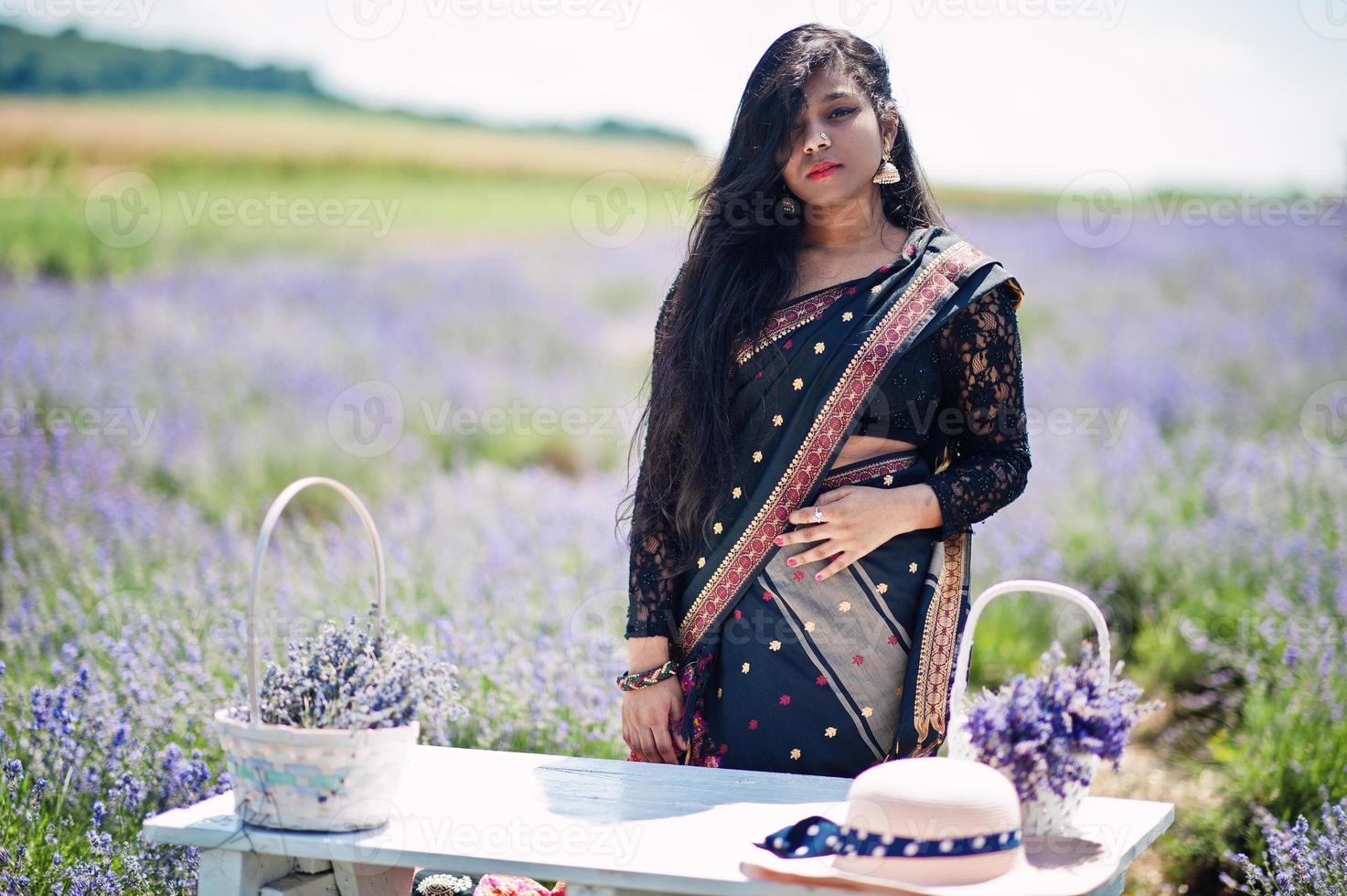 mooi indiaans meisje draagt saree india traditionele kleding in paars lavendelveld. foto