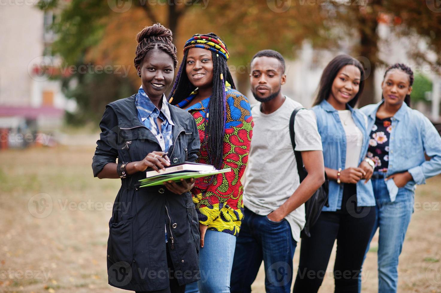 rij van groep vijf Afrikaanse studenten die samen tijd doorbrengen op de campus op het universiteitsterrein. zwarte afro-vrienden studeren. onderwijs thema. foto