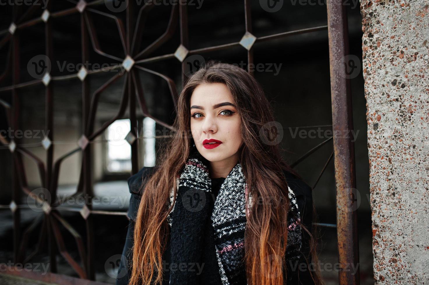 brunette stijlvolle casual meisje in sjaal tegen verlaten fabrieksplaats. foto