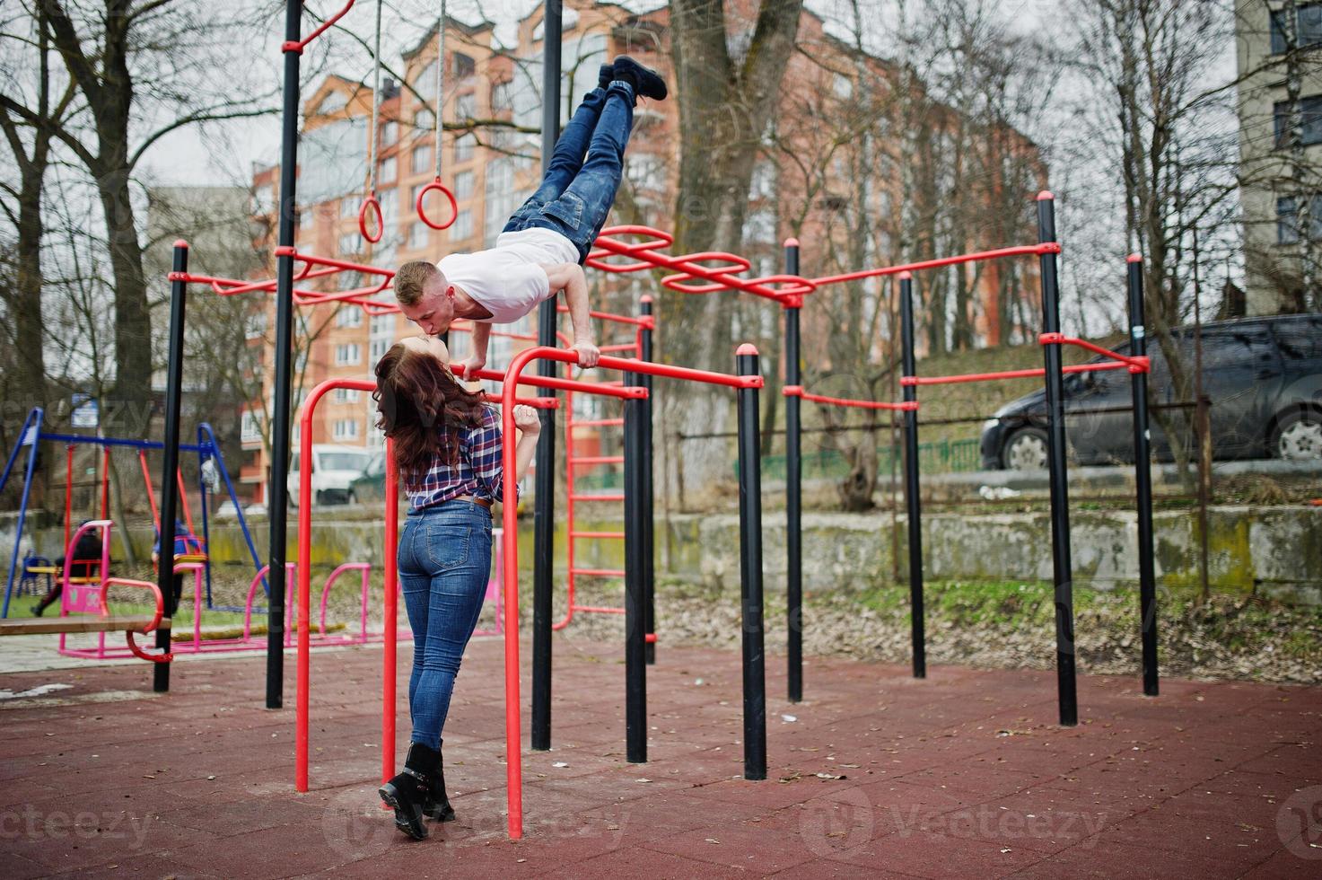 stijlvolle paar slijtage op geruit hemd verliefd samen zoenen op bars training. foto