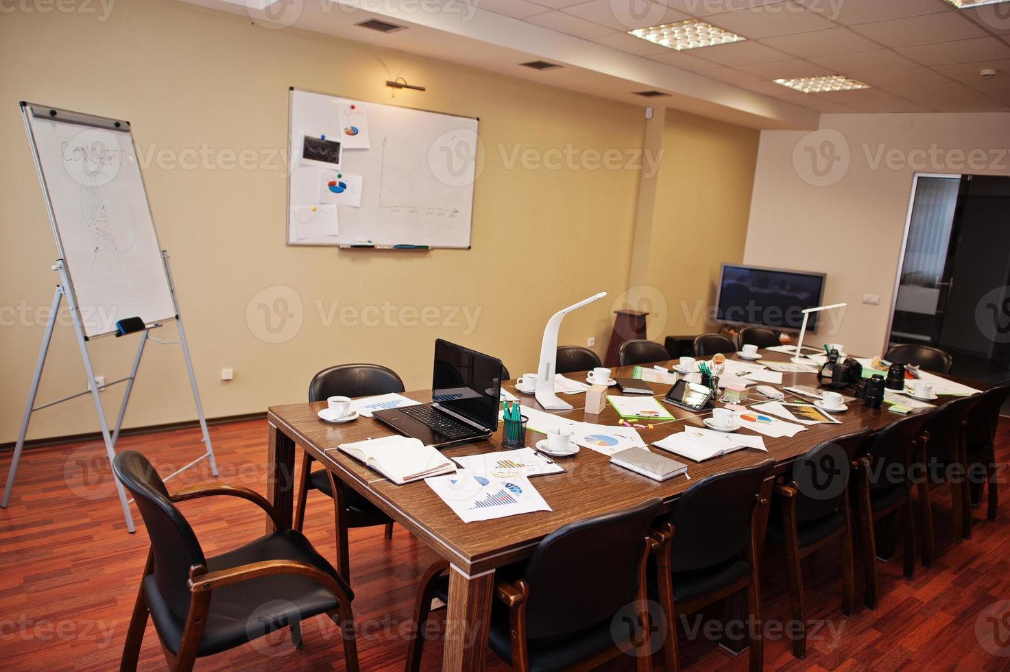 modern zakelijk kantoorinterieur met tafels en stoelen, laptop, camera en kantoorbenodigdheden zonder werknemers. foto