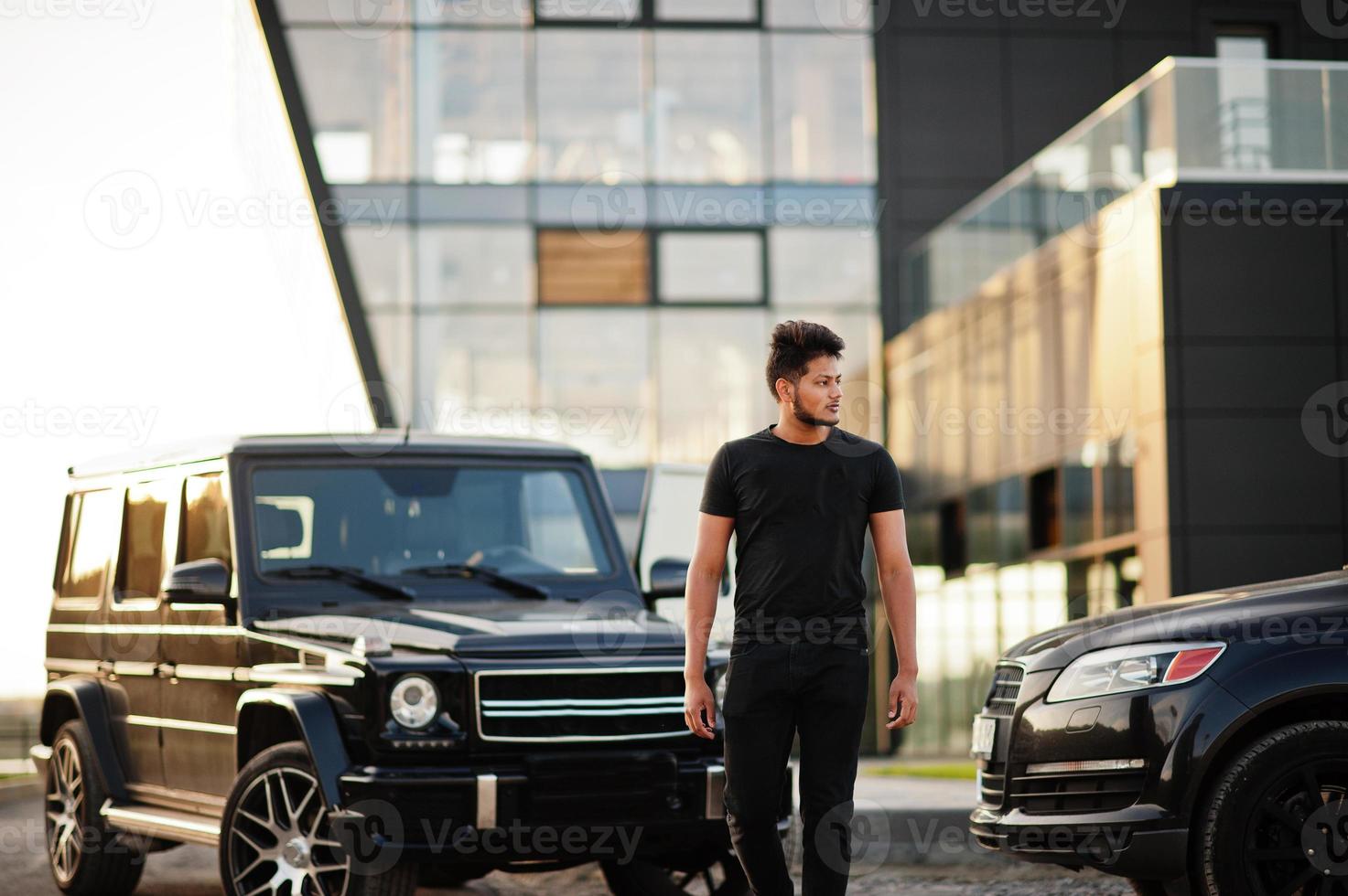 aziatische man draagt helemaal zwart in de buurt van suv-auto. foto