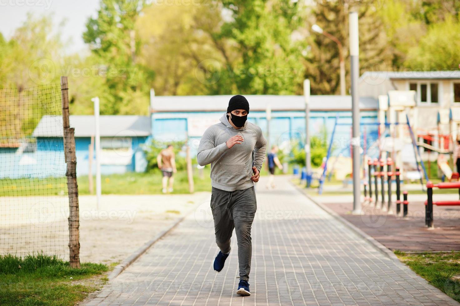 portret sport arabische man met zwart medisch gezichtsmasker buiten rennen tijdens de quarantaine van het coronavirus. foto