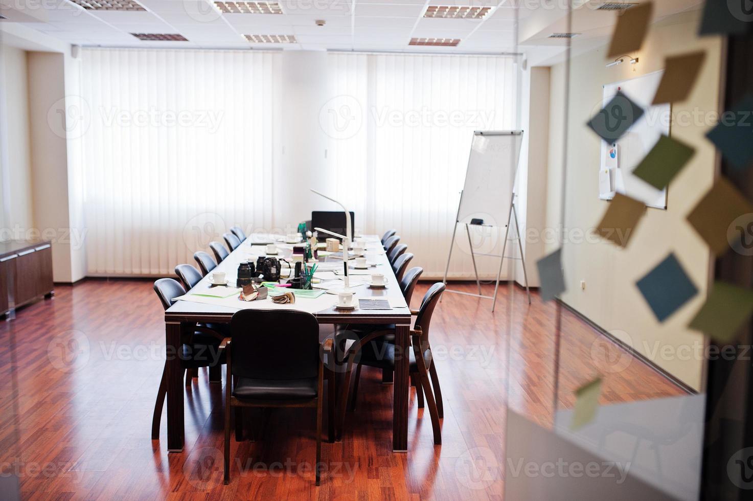 modern zakelijk kantoorinterieur met tafels en stoelen, laptop, camera en kantoorbenodigdheden zonder werknemers. foto