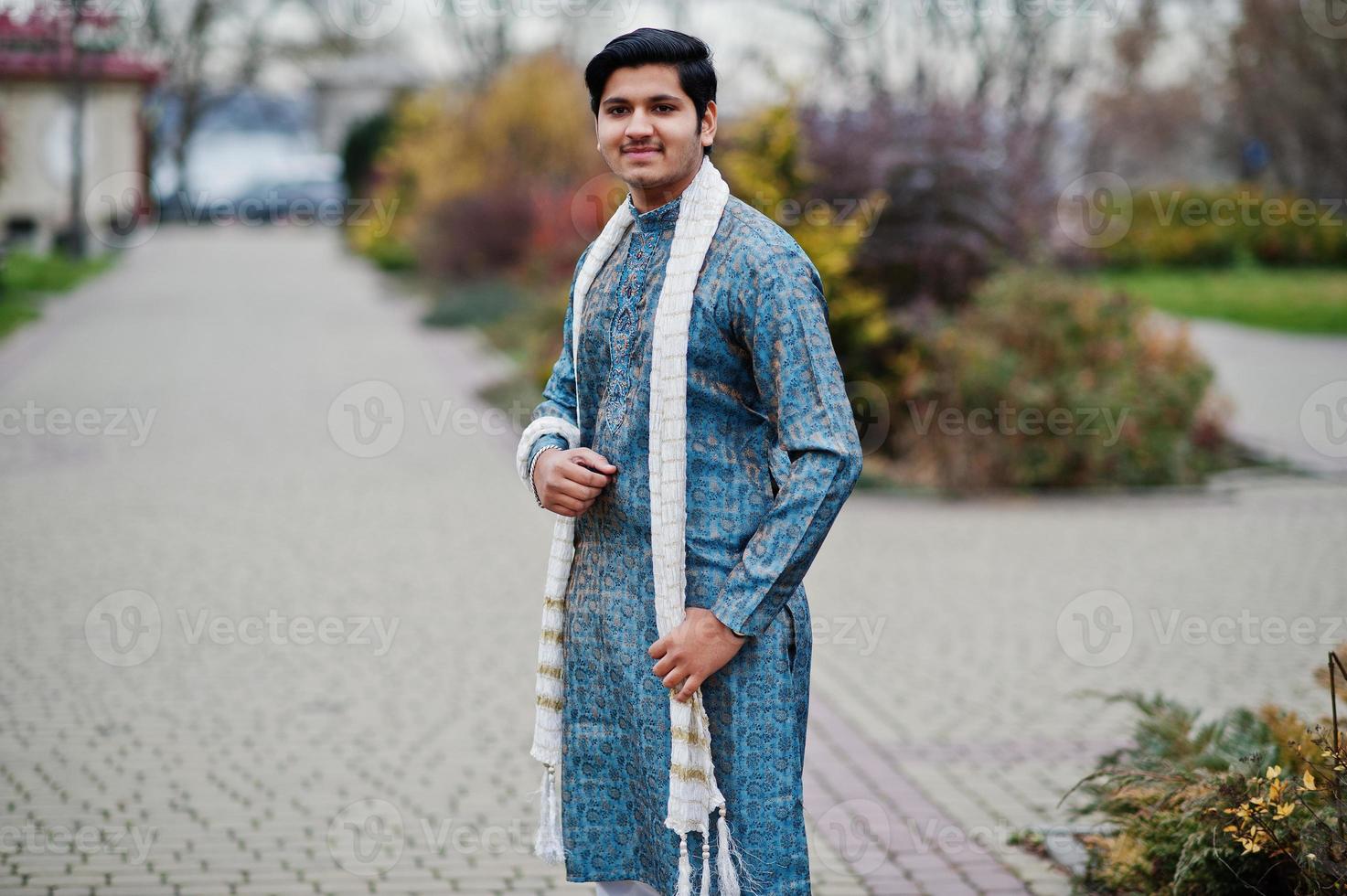 indiase man draagt traditionele kleding met witte sjaal buiten geposeerd. foto