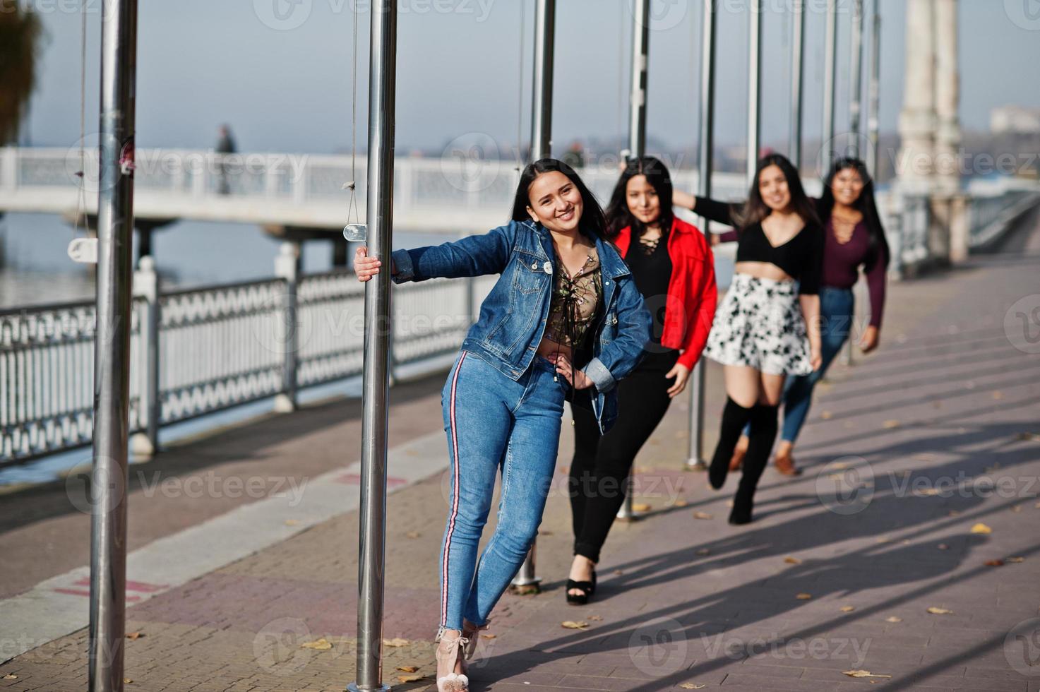 groep van vier gelukkige en mooie latino-meisjes uit ecuador poseerden op straat. foto