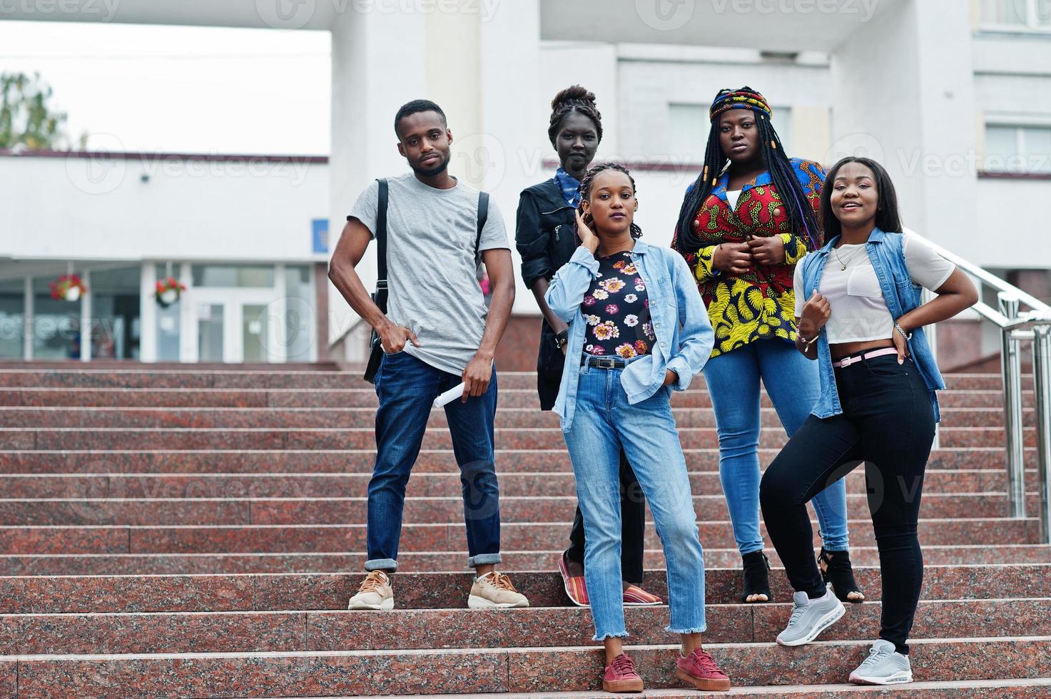 groep van vijf afrikaanse studenten die samen tijd doorbrengen op de campus op de universiteitswerf. zwarte afro-vrienden studeren. onderwijs thema. foto