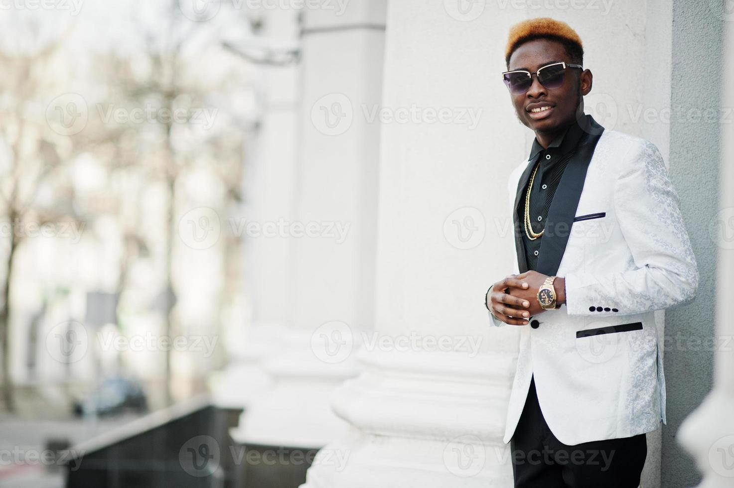 chique knappe Afro-Amerikaanse man in wit pak en zonnebril. foto