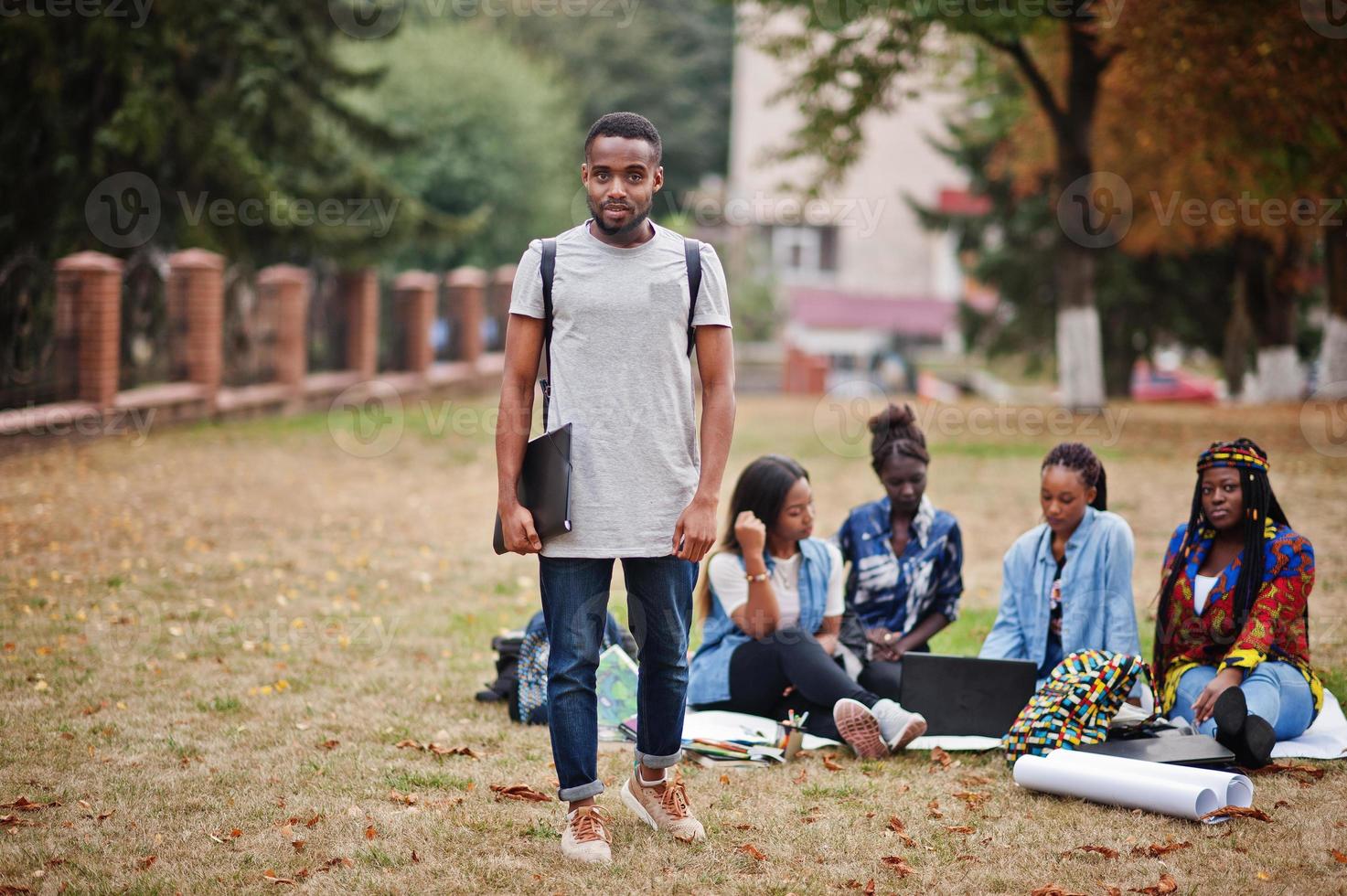 groep van vijf afrikaanse studenten die samen tijd doorbrengen op de campus op de universiteitswerf. zwarte afro-vrienden studeren. onderwijs thema. foto