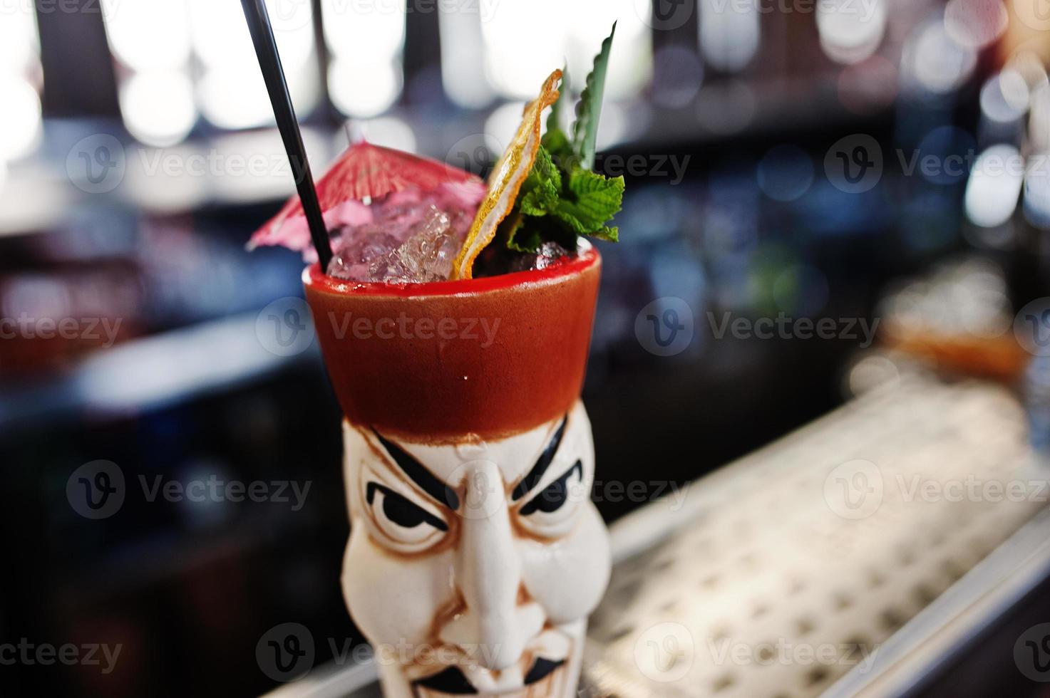 alcoholische cocktail met munt en limoen in oorspronkelijk voodoo aarden glas op bartafel. foto