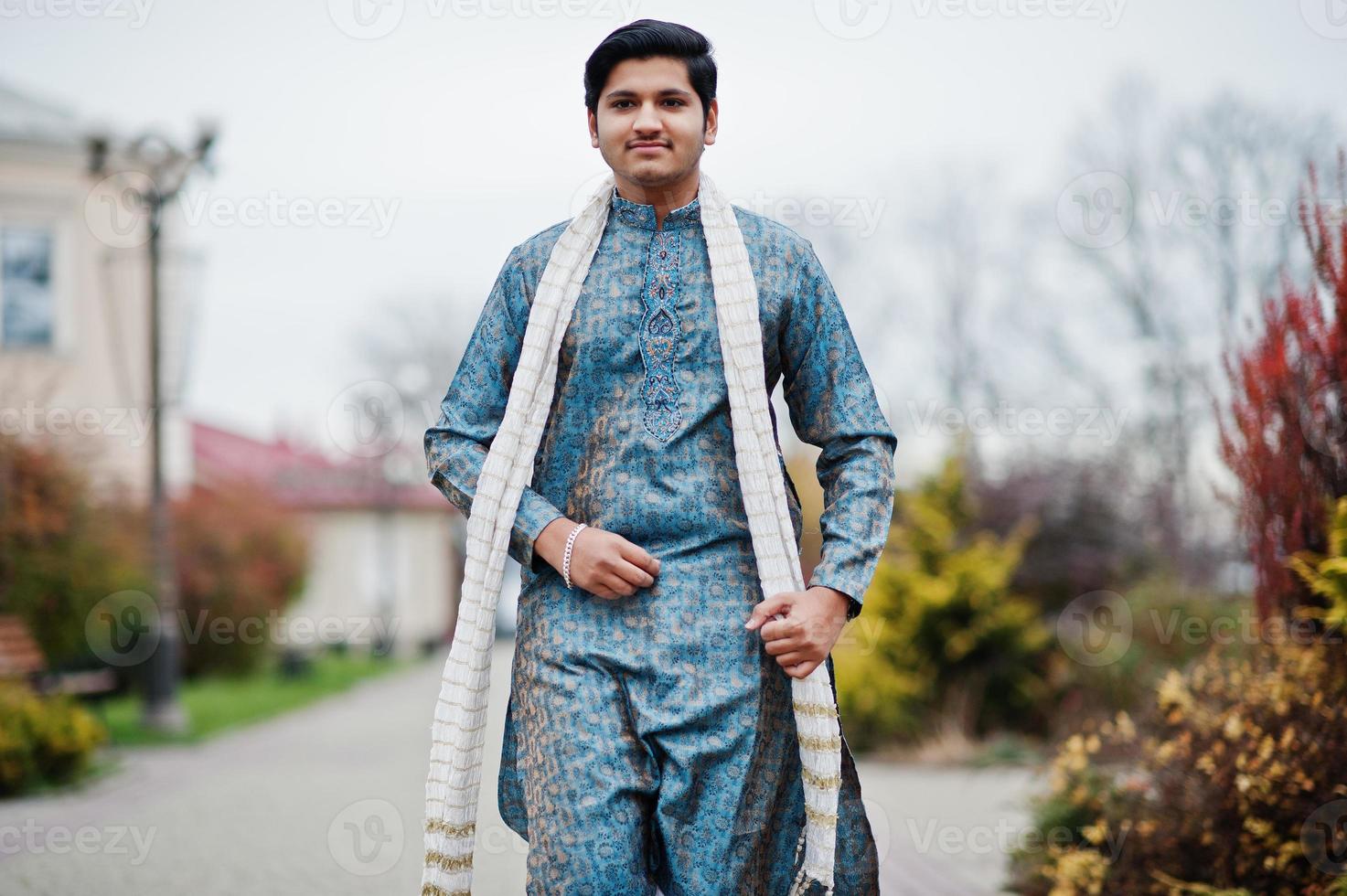 indiase man draagt traditionele kleding met witte sjaal buiten geposeerd. foto