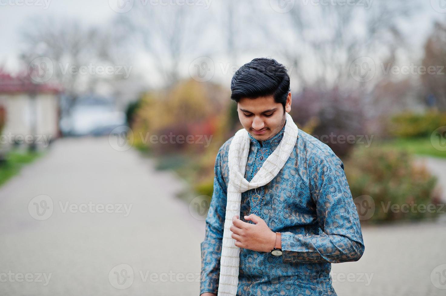 indiase man draagt traditionele kleding met witte sjaal buiten geposeerd. foto