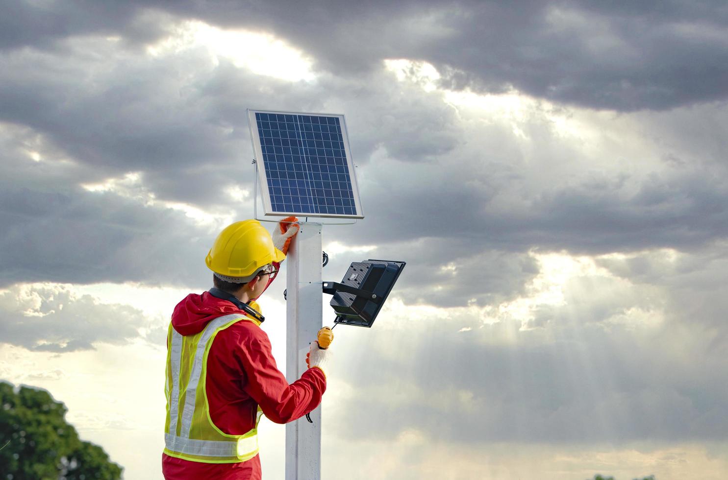 man tijdens de installatie van fotovoltaïsche zonnepanelen in landbouwgebieden foto