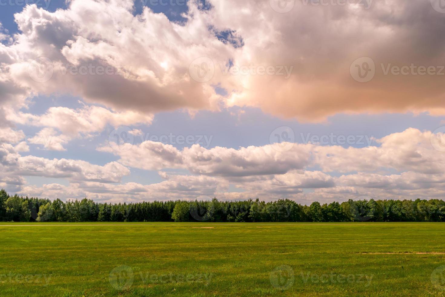 roze wolken bij zonsondergang boven een landbouwveld foto