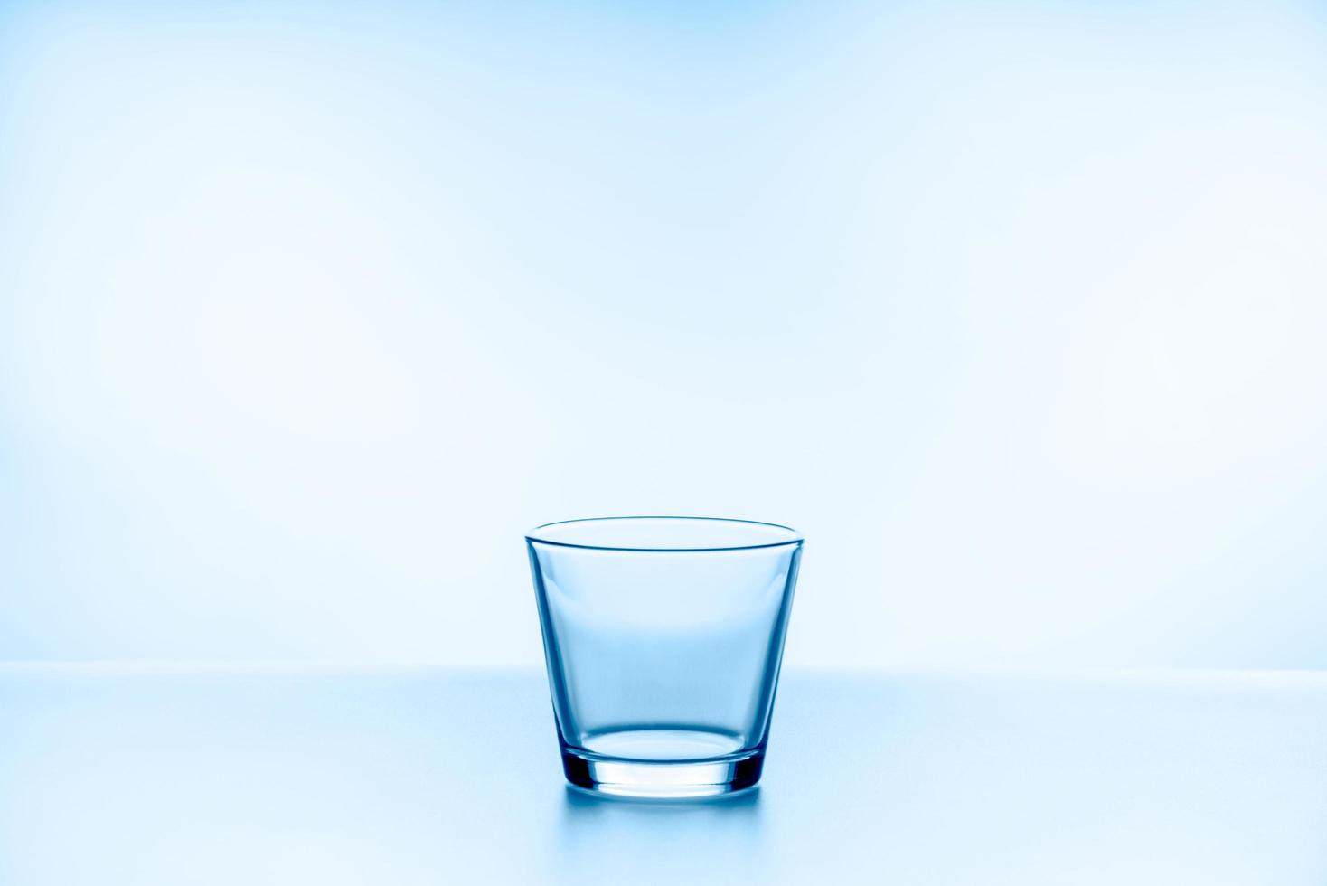 glas. glas water op een blauwe achtergrond foto