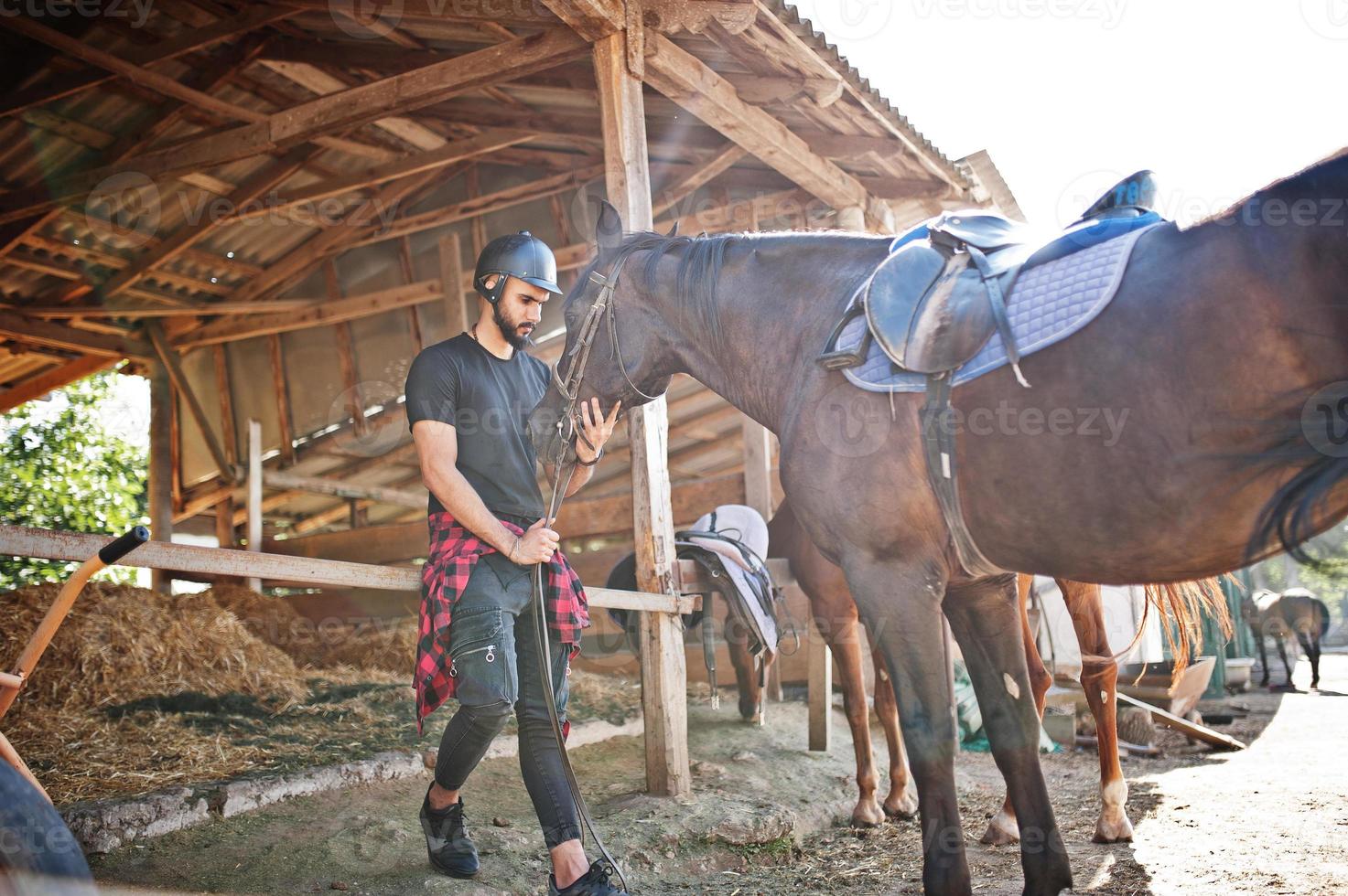 arabische lange baard man slijtage in zwarte helm met arabische paard. foto