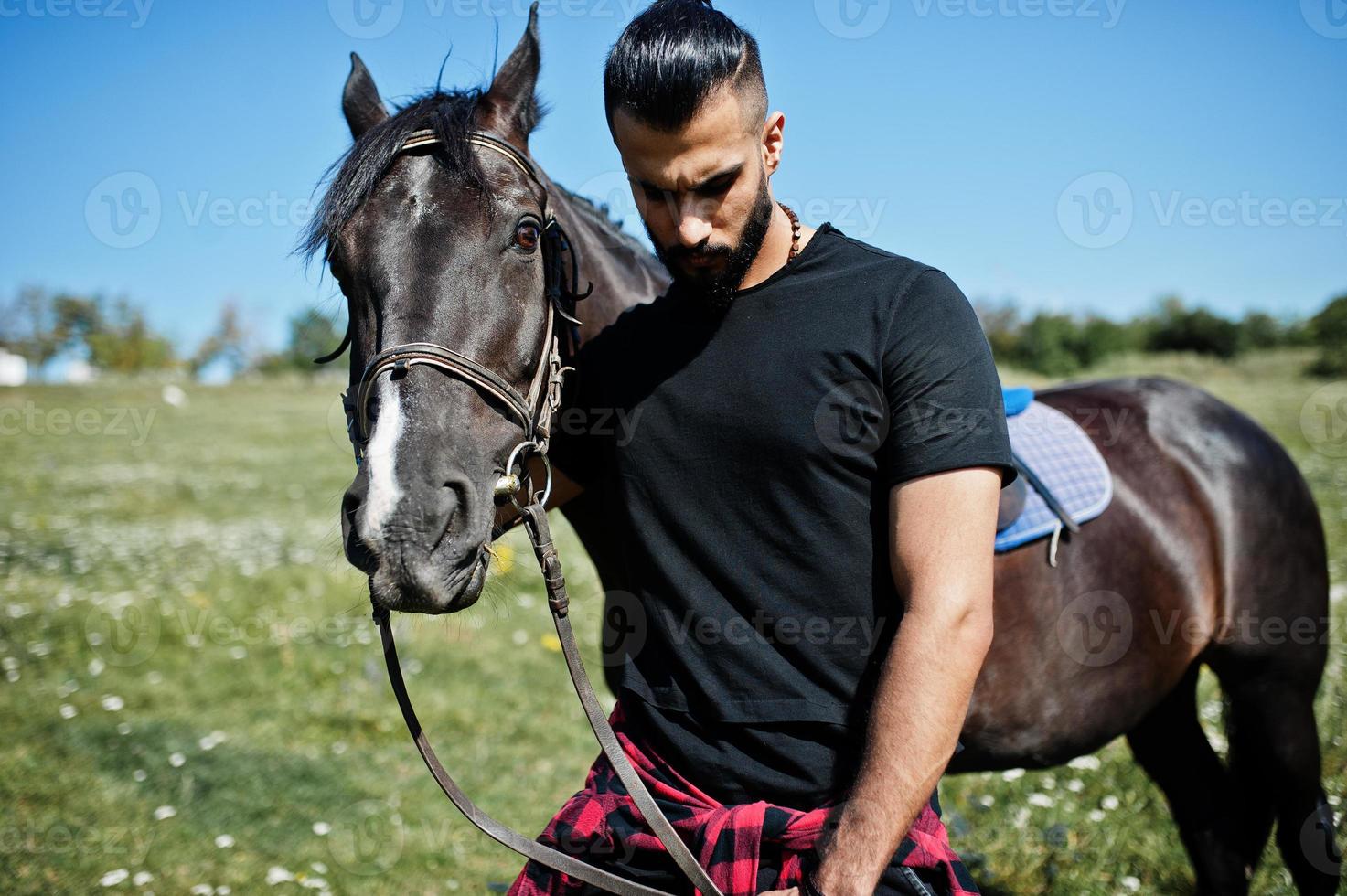 Arabische lange baard man slijtage in het zwart met Arabisch paard. foto