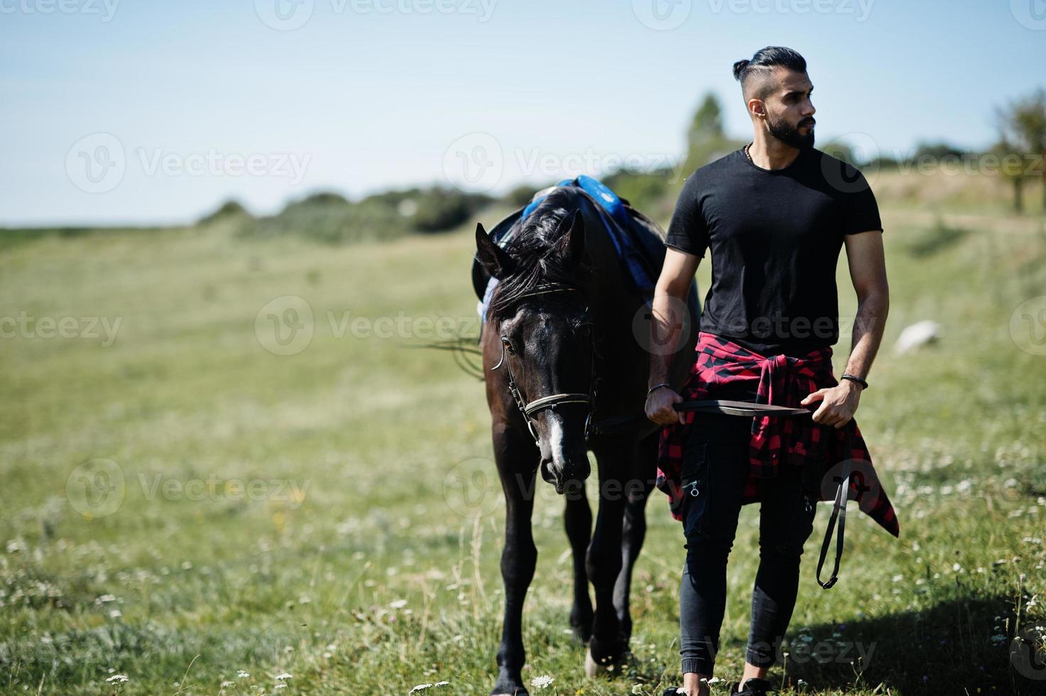 Arabische lange baard man slijtage in het zwart met Arabisch paard. foto