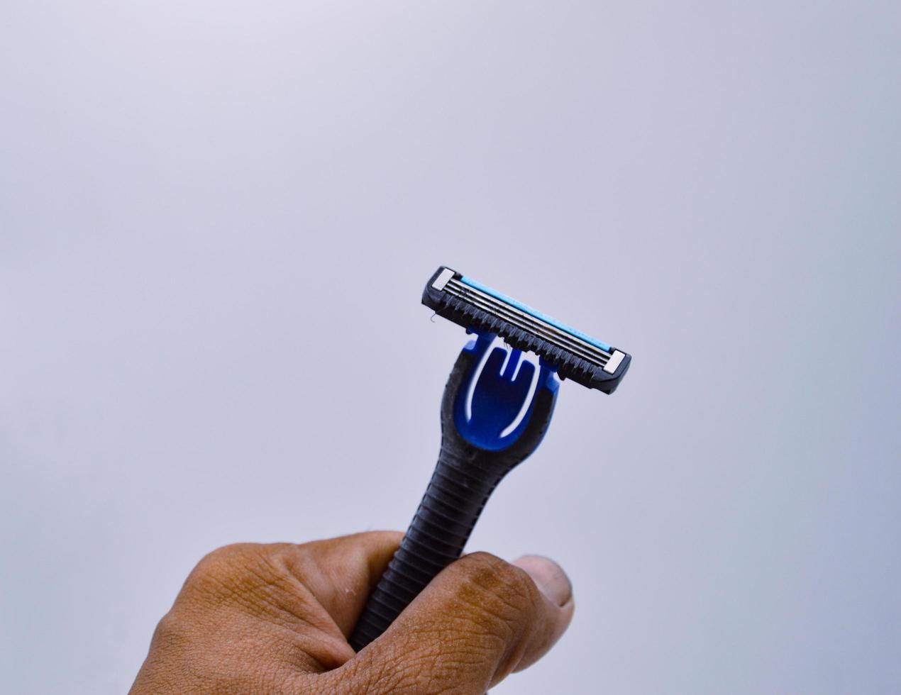 mannelijke hand met een scheermes zwart witte achtergrond concept baard trimmen foto
