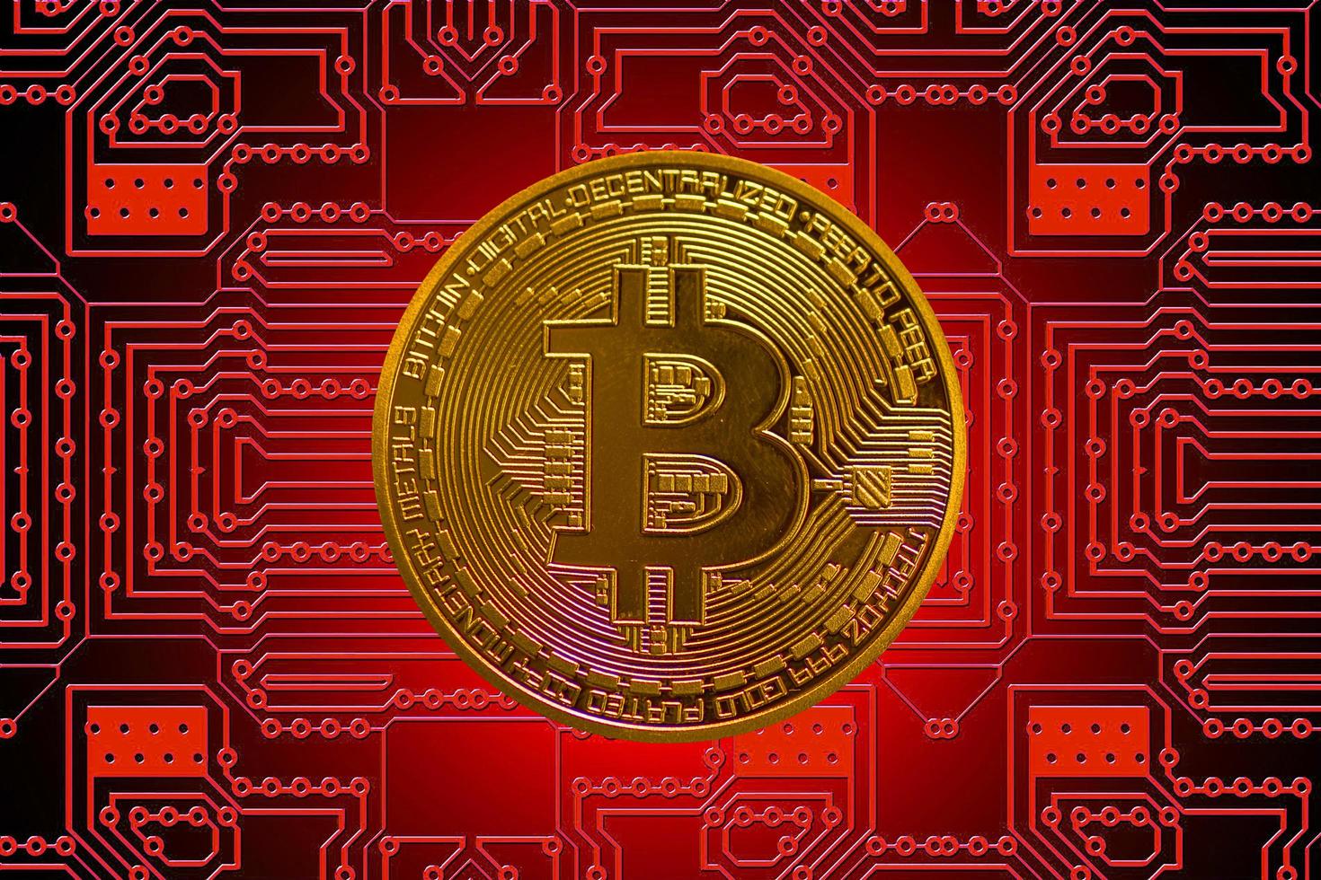 gouden waardevolle enkele bitcoin van cryptovaluta met een rood bord op de achtergrond midden foto