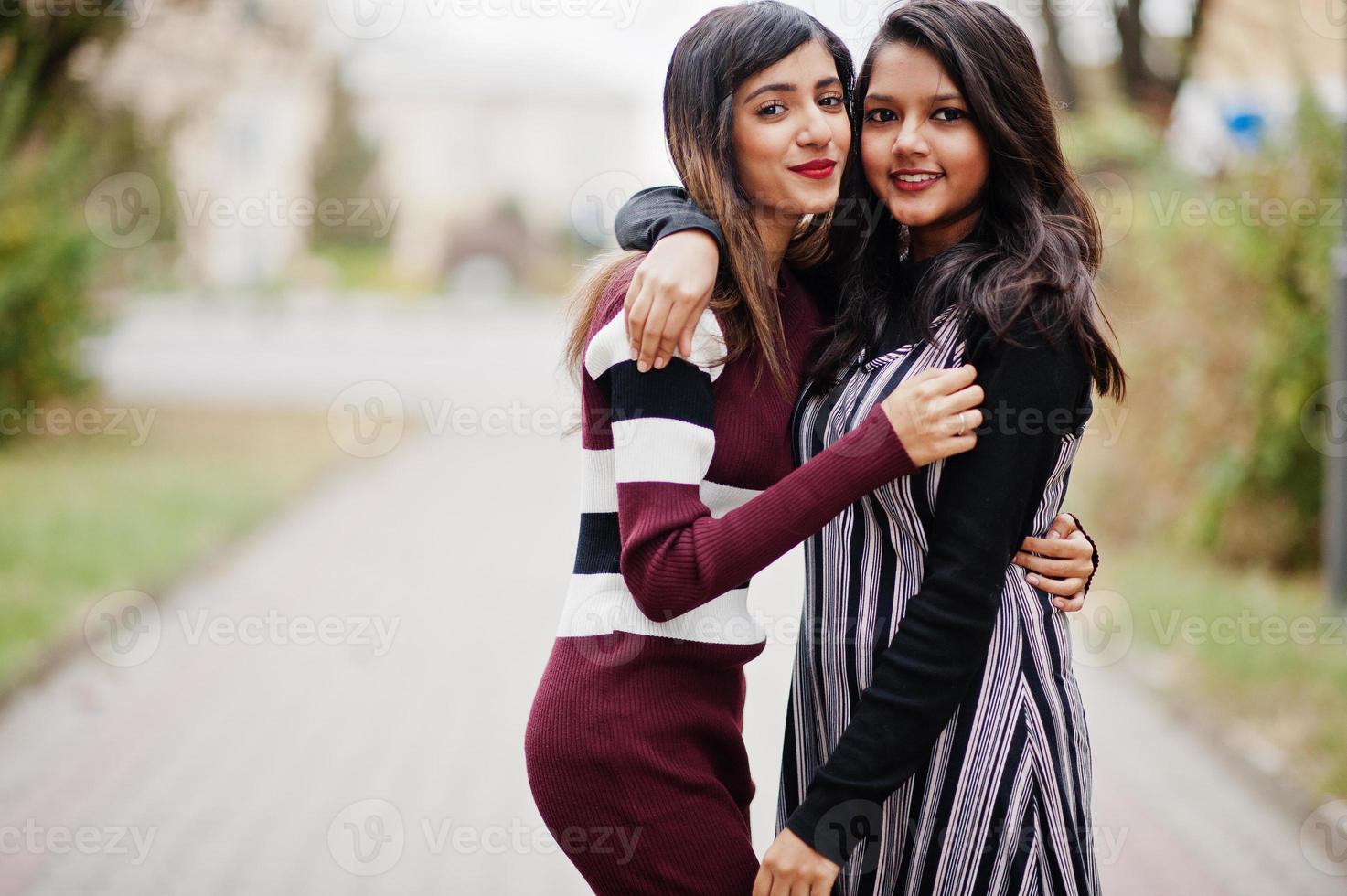 portret van twee jonge mooie Indiase of Zuid-Aziatische tienermeisjes in jurk die samen op straat lopen. foto