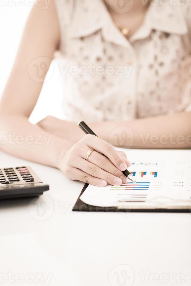 vrouwenhand met pen en bedrijfsrapport. boekhouding foto