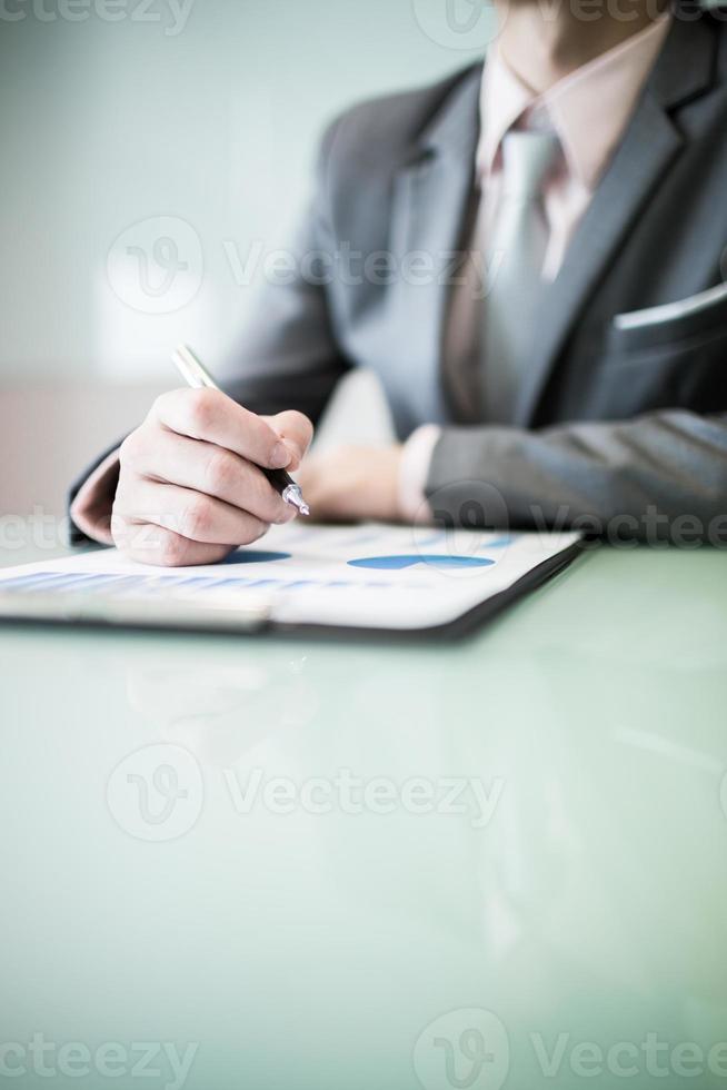 bedrijfsrapport en man hand met pen foto