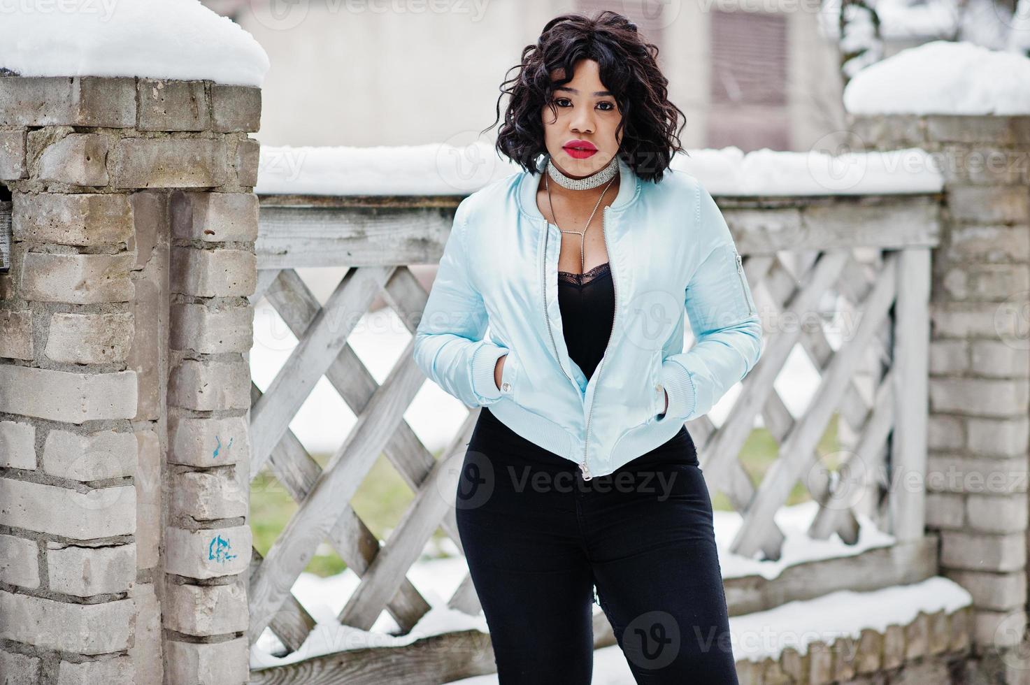 stijlvolle Afro-Amerikaanse plus size model in de straten van de stad op winterdag. foto