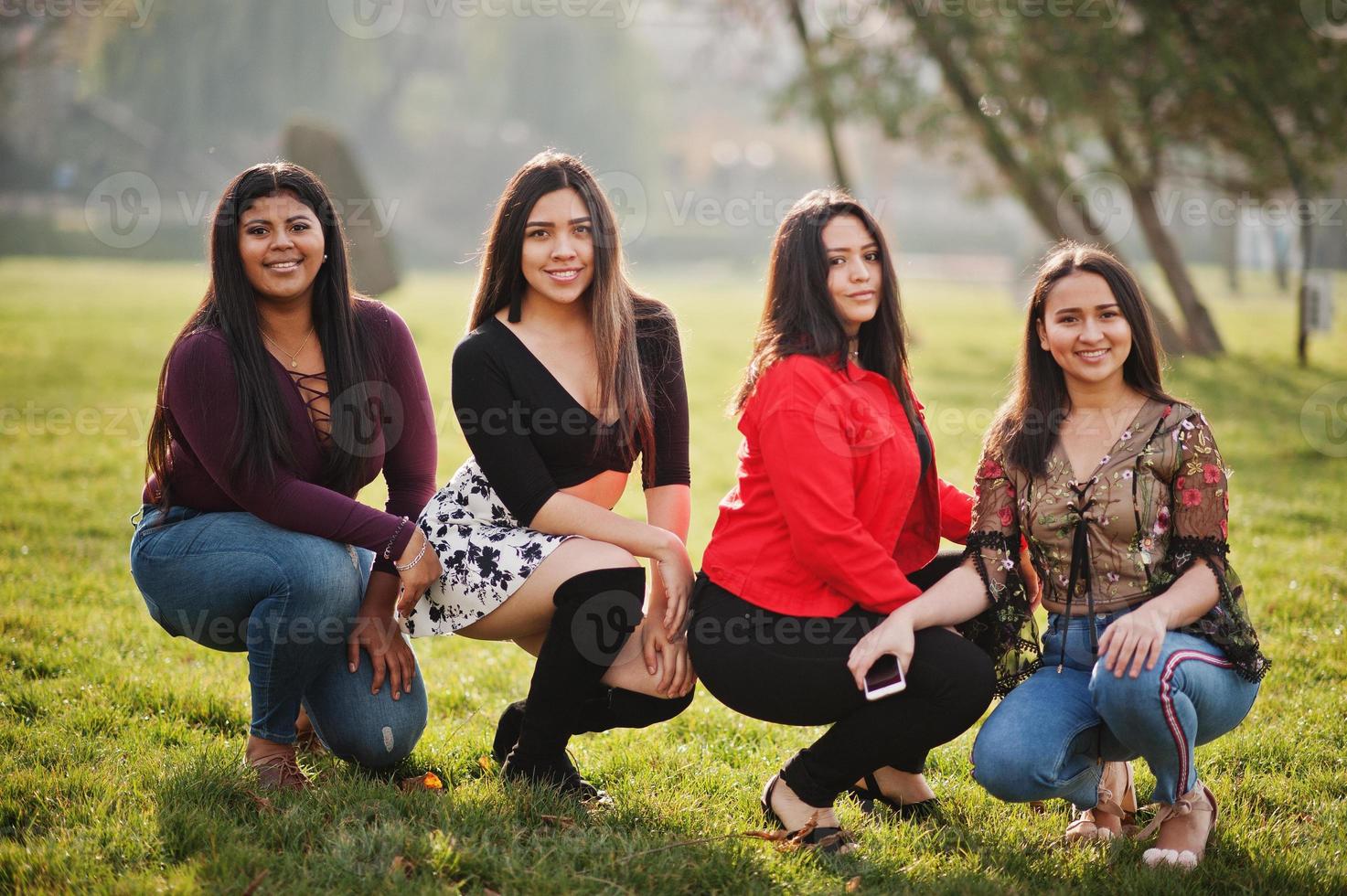 groep van vier gelukkige en mooie latino-meisjes uit ecuador poseerden op straat. foto