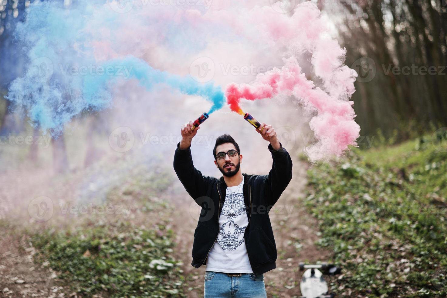 straatstijl arabische man met bril houdt handflare vast met rode en blauwe rookgranaatbom. foto