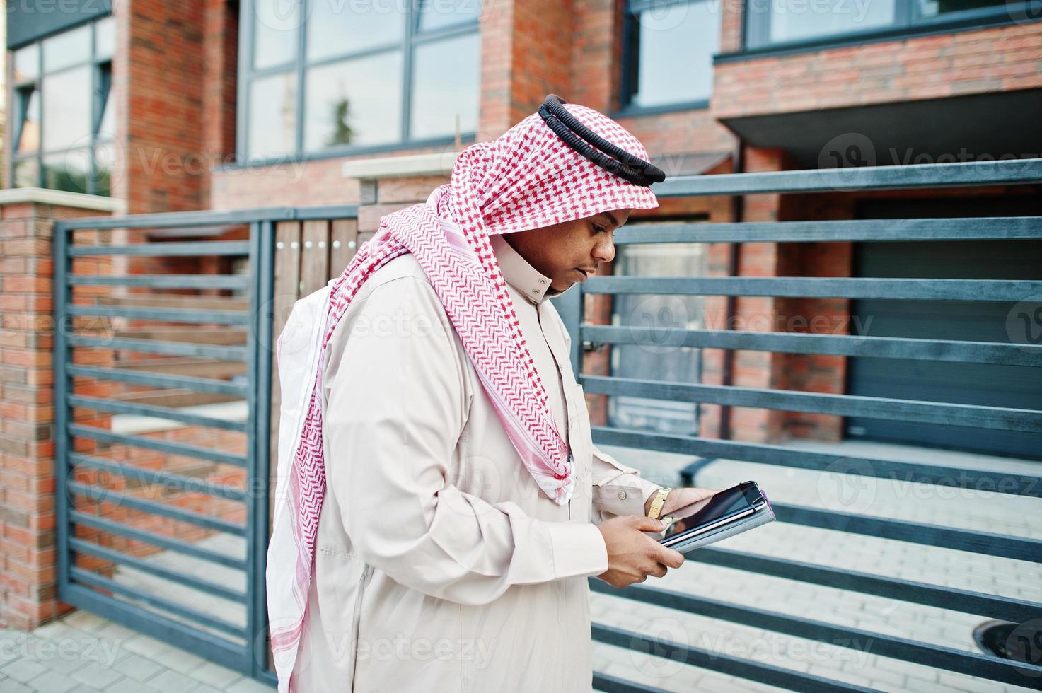 Arabische man uit het Midden-Oosten poseerde op straat tegen modern gebouw met tablet bij de hand. foto