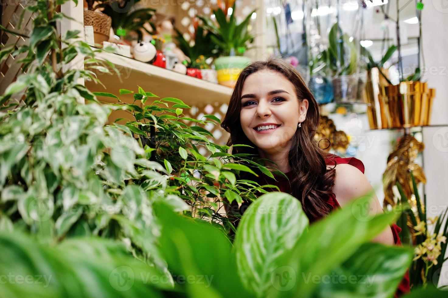 brunette meisje in het rood bloemen kopen bij bloemenwinkel. foto