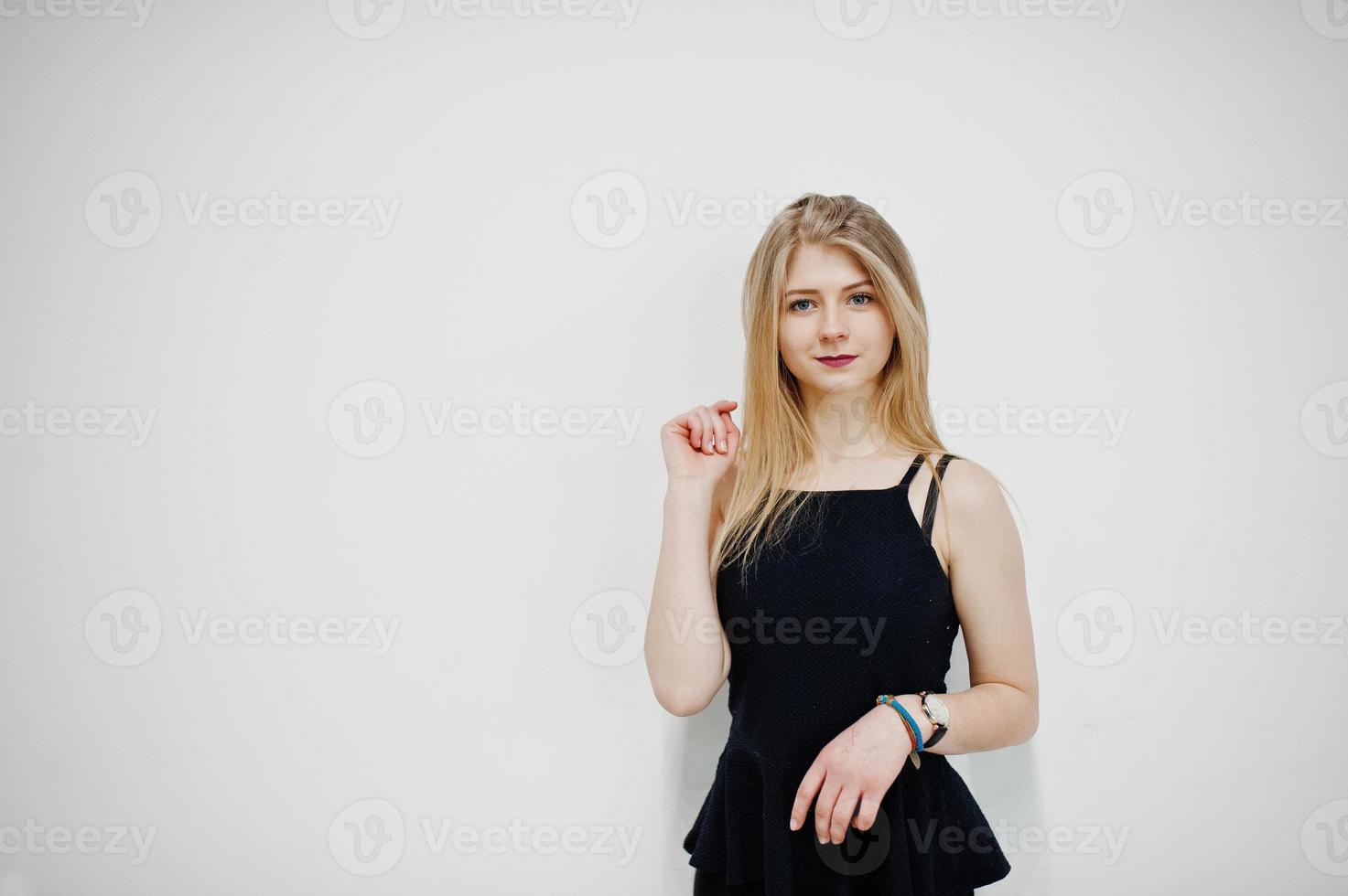 portret van blond meisje in zwarte slijtage tegen een witte achtergrond. foto