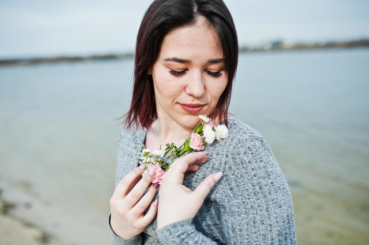 portret van brunette meisje in grijze jurk achtergrond het meer. foto